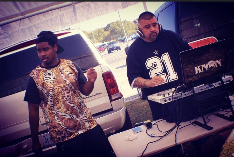 Two men standing next to each other in front of a table.