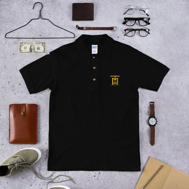 A black polo shirt with a yellow logo and some other items