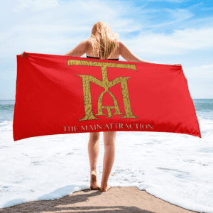 A woman standing on the beach holding a towel.