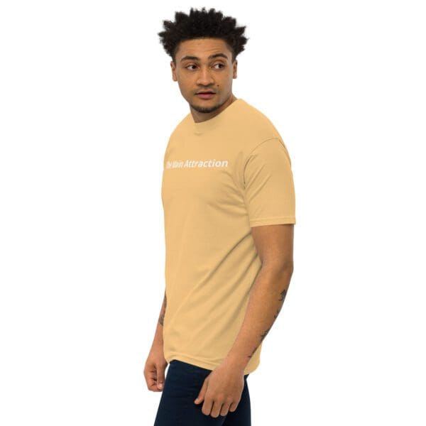 A man wearing a tan t-shirt with the words " be yourself ".